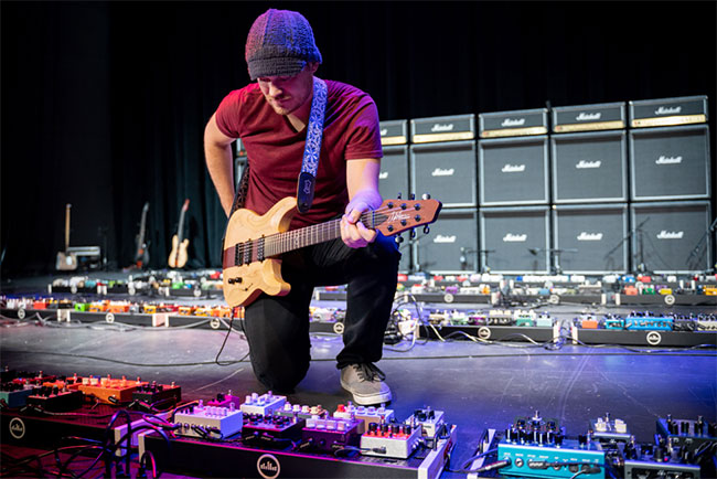 Rob Scallon tweaking his pedal settings with the worlds largest pedalboard
